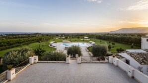 Terraza en la azotea con piscina, rodeada de vegetación y un paisaje montañoso.