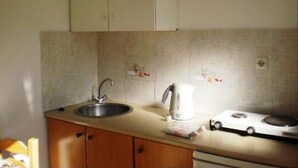 A kitchen with a sink, a kettle, and a stove. - Christina Studios (Kos)
