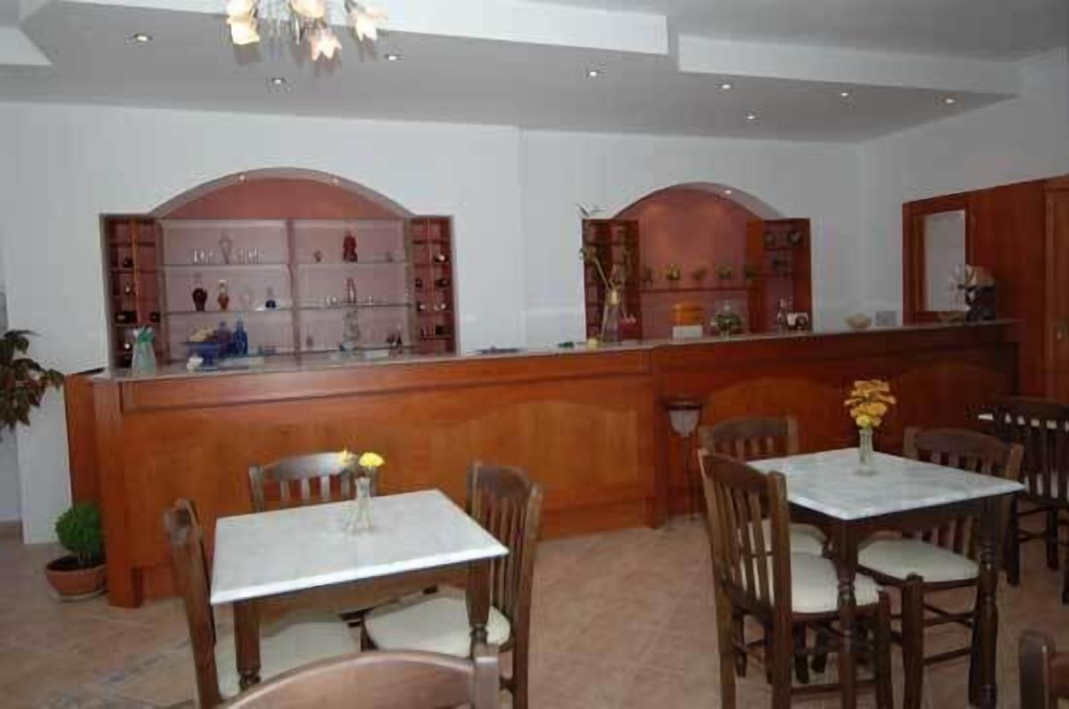 A dining area with wooden furniture, a marble table, and a counter with shelves.