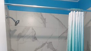 Un bagno con una vasca, una doccetta, un water e una tenda.