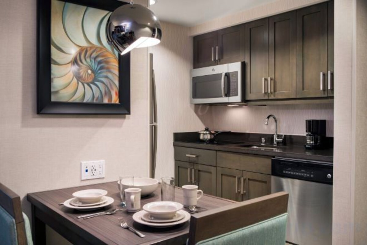 A modern kitchen with dark cabinets, a microwave, and a dishwasher.