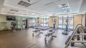 Un gimnasio con cintas de correr, elípticas y equipo de pesas.