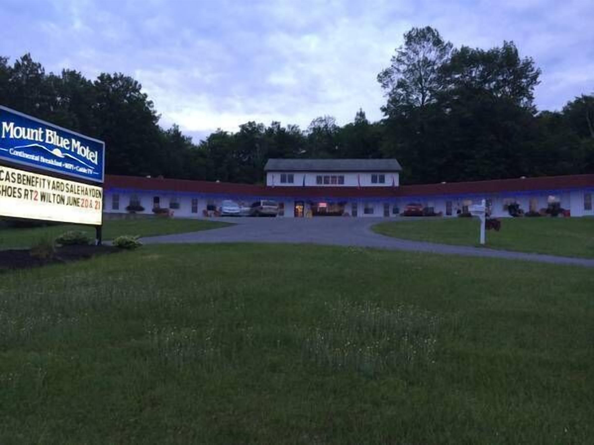 A motel with a signboard advertising the Mount Blue Motel and a sale event.