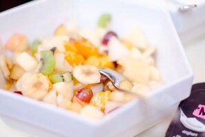 A bowl of fruit salad with a spoon. - Hotel Goldener Hirsch (Bayreuth)