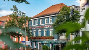 A hotel with a traditional facade, multiple windows, and a sign indicating it is a hotel. - Hotel Goldener Hirsch (Bayreuth)
