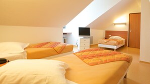 A room with two beds, a TV, and a wooden door.