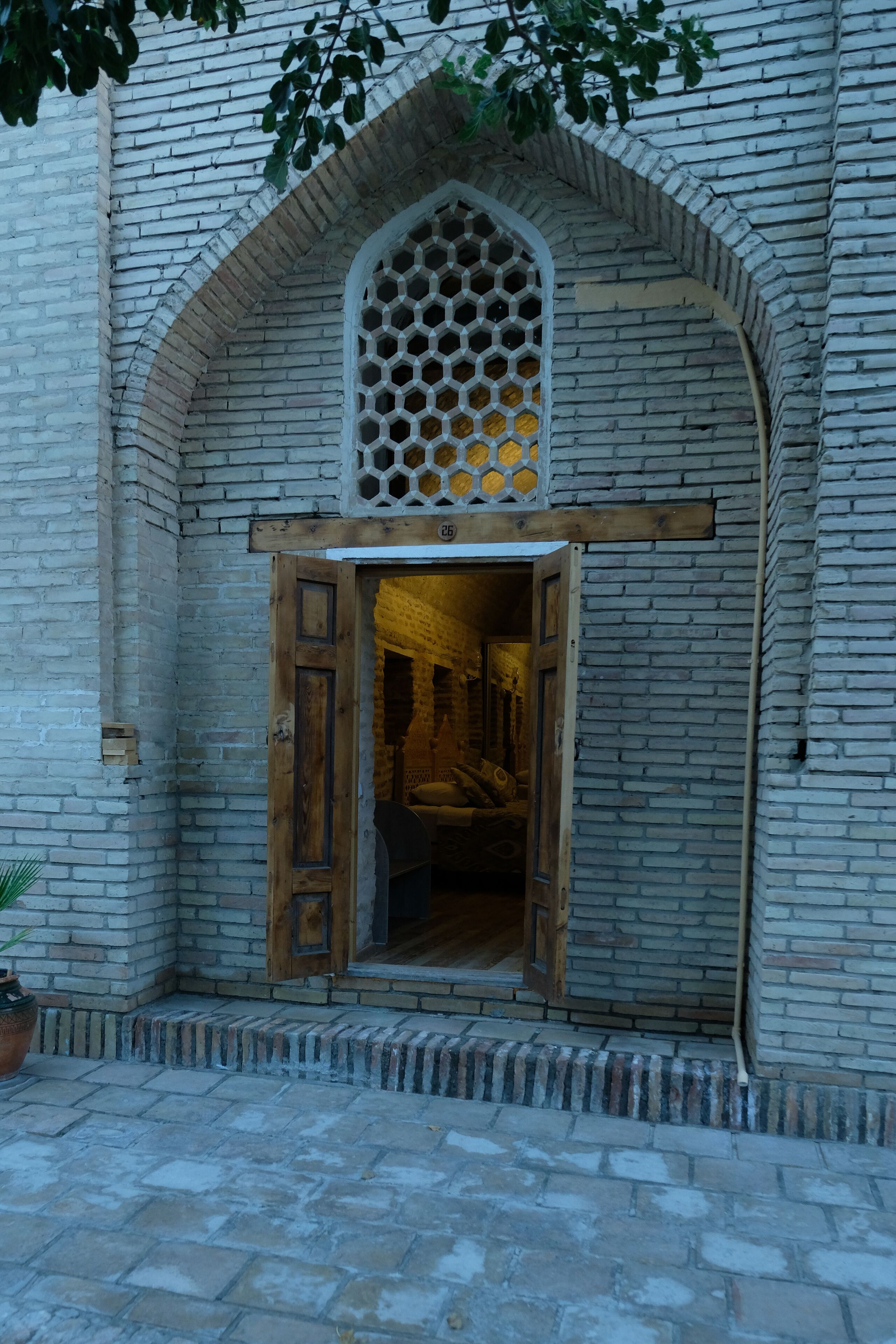Una entrada de edificio con puerta de madera y arco de ladrillo.