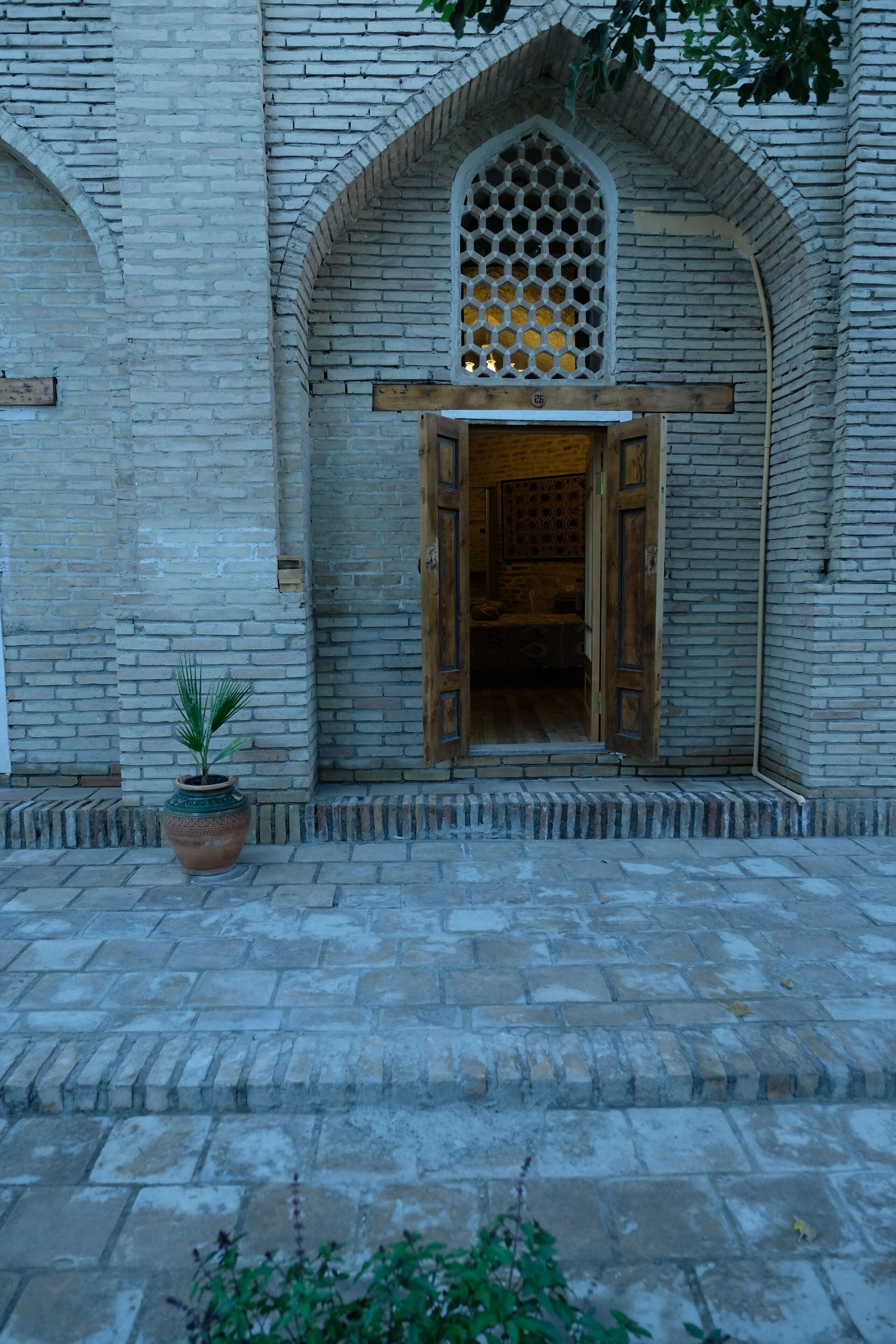 A stone building with a wooden door and a window with a lattice design.