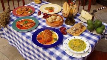Et bord dækket med forskellige retter, herunder et stykke kød, en skål suppe og et brød.
