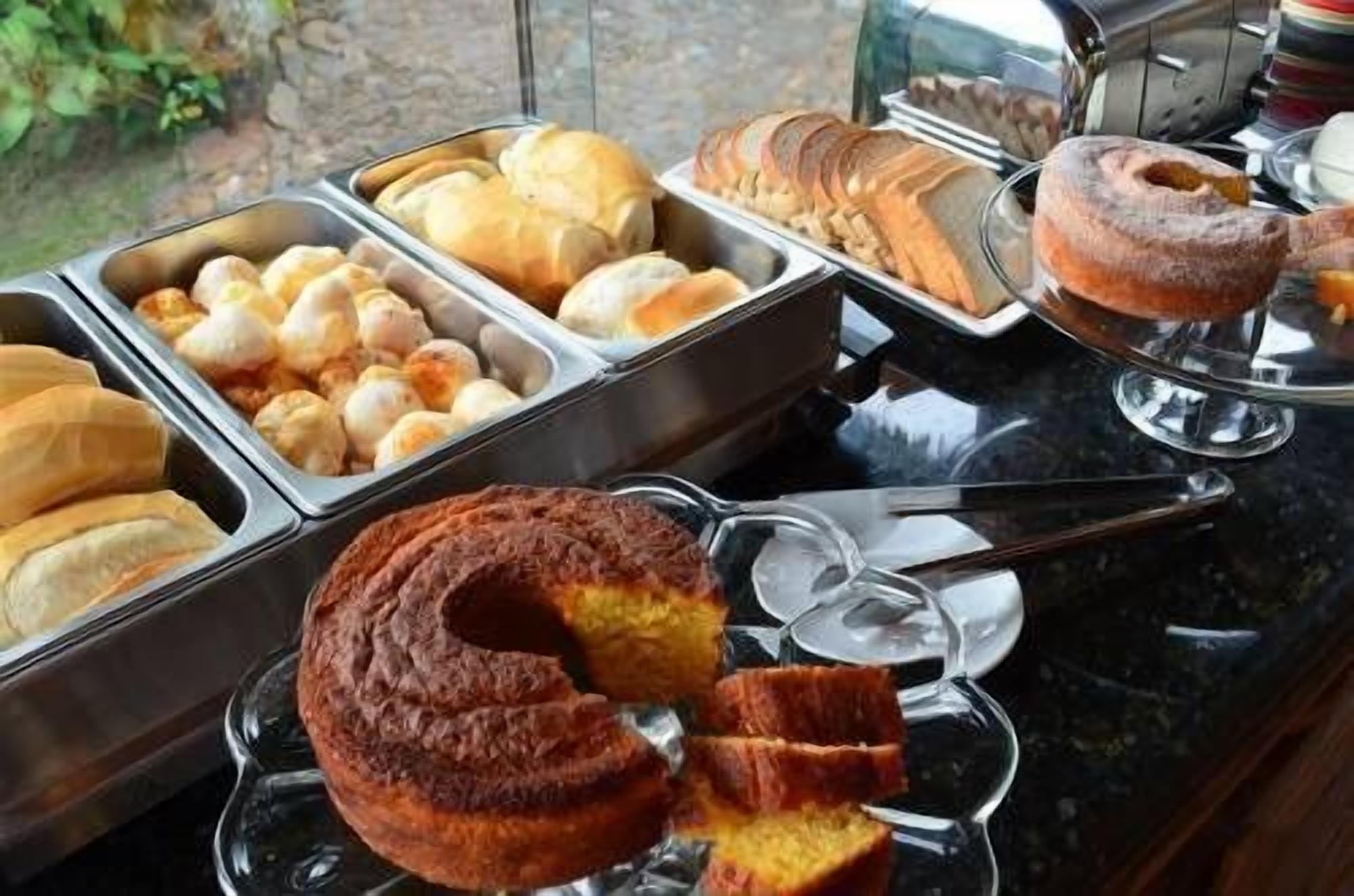 A buffet with various baked goods including cakes, pastries, and donuts.