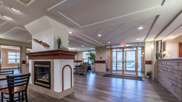 Eine geräumige Lobby mit Kamin, Holzboden und einer Rezeption.