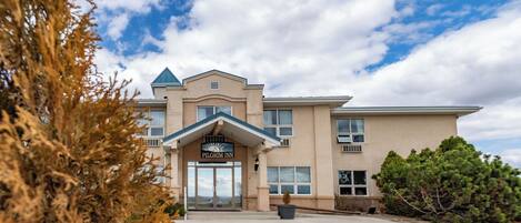 A building with a sign reading "Pilgrim Inn" and a large entrance.