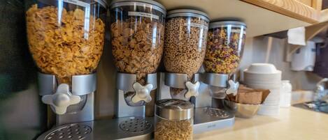 A kitchen with four dispensers for different types of cereal.