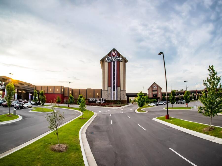 Un edificio comercial grande con un letrero prominente de 'Chesapeake', varios estacionamientos y una zona ajardinada bien cuidada con árboles.