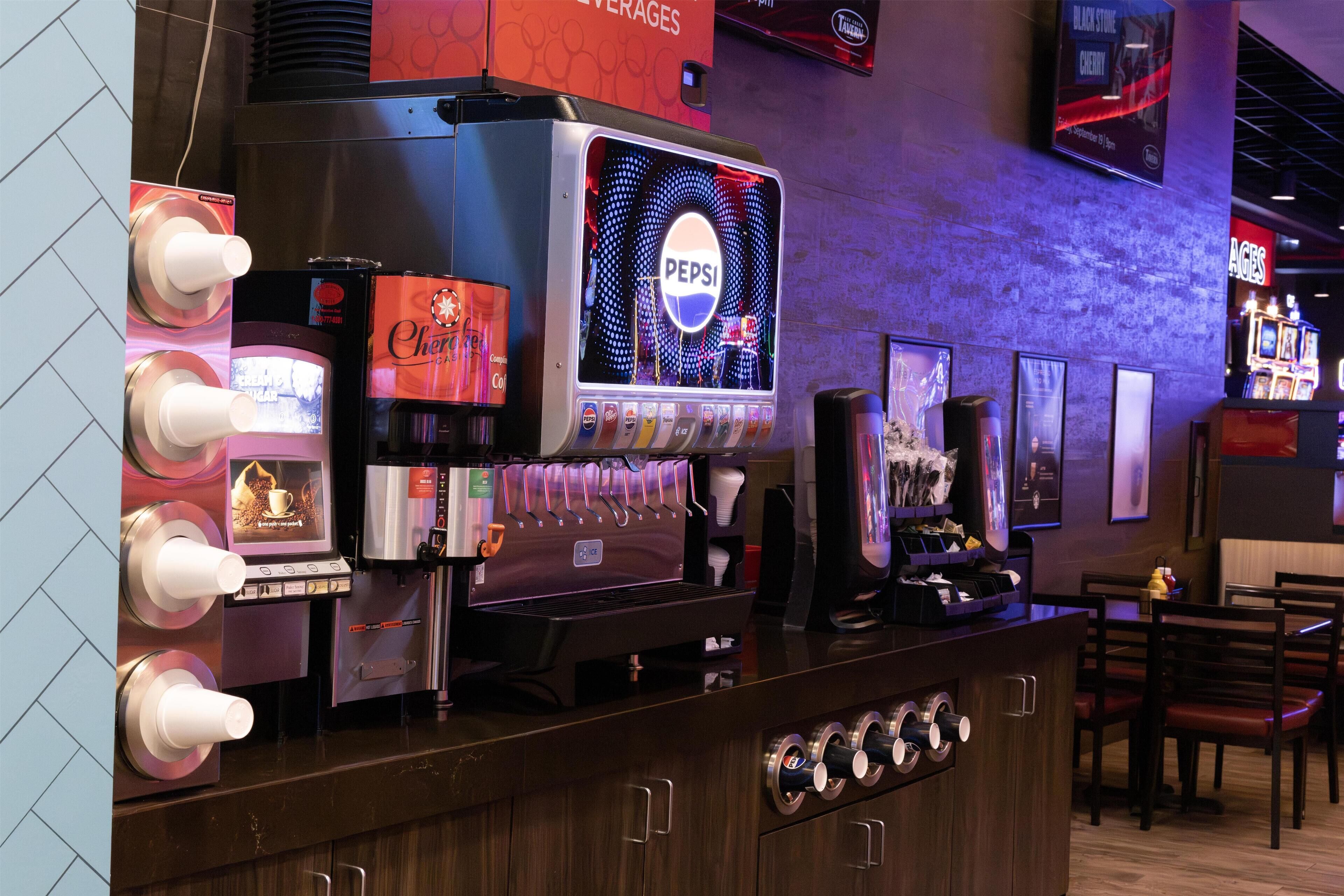A coffee machine with multiple drink options, a Pepsi display, and a menu board.