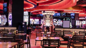 A casino interior with slot machines, tables, and chairs. - Cherokee Casino & Hotel Roland (Roland)