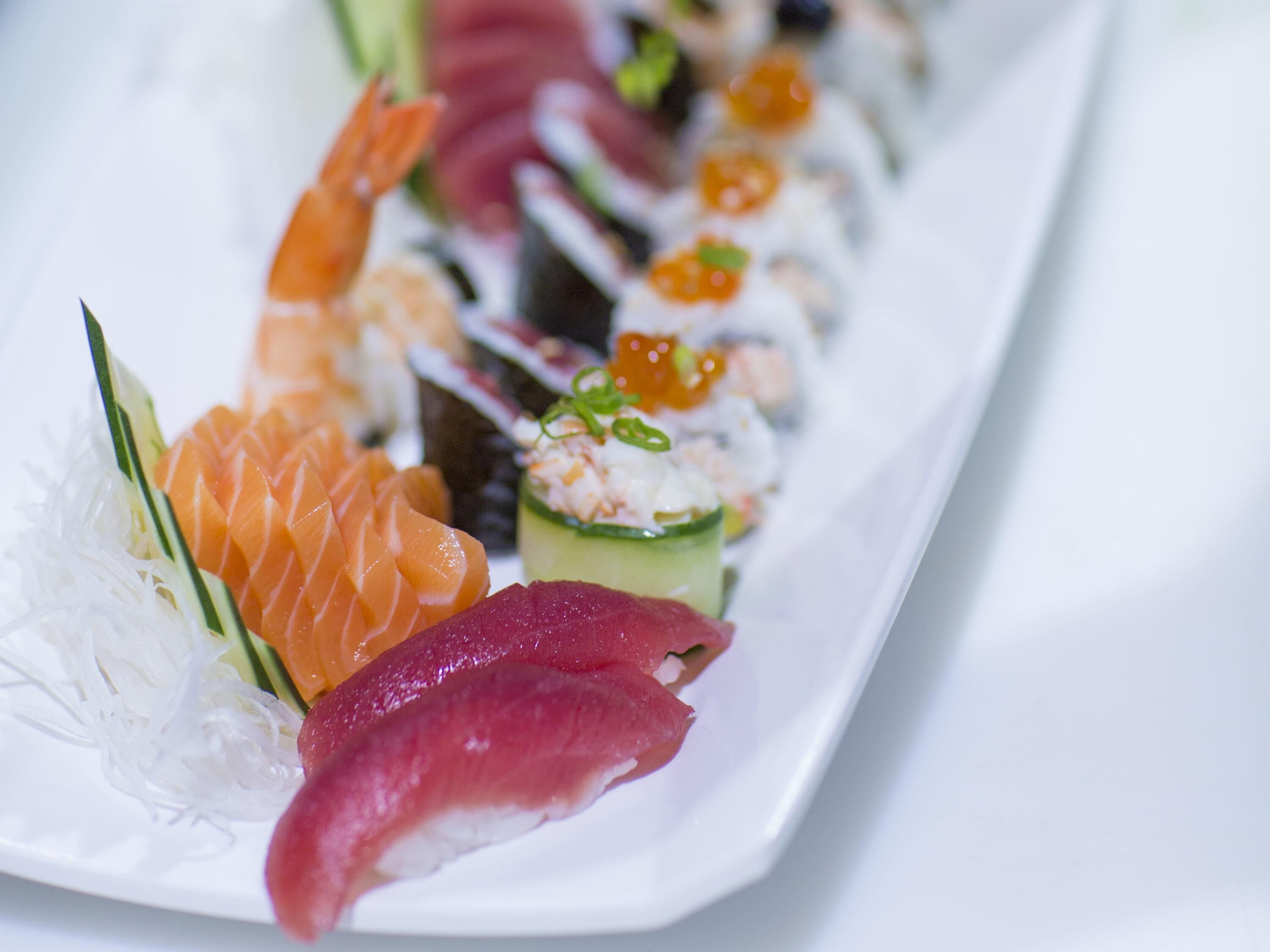 Diversos tipos de sushi sobre um prato branco.