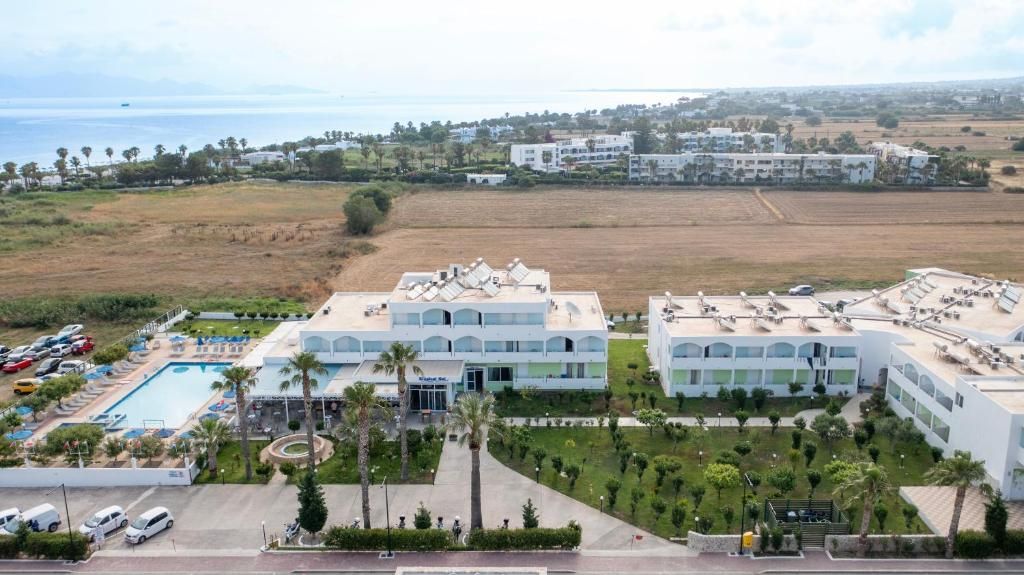 A resort with multiple buildings, a swimming pool, and a parking area.