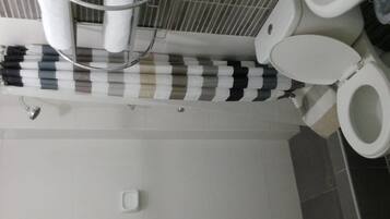A bathroom with a toilet, a sink, and a towel rack with striped towels.