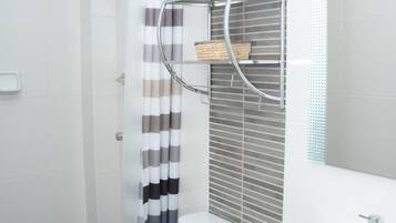 Un baño moderno con inodoro, lavamanos y zona de ducha.
