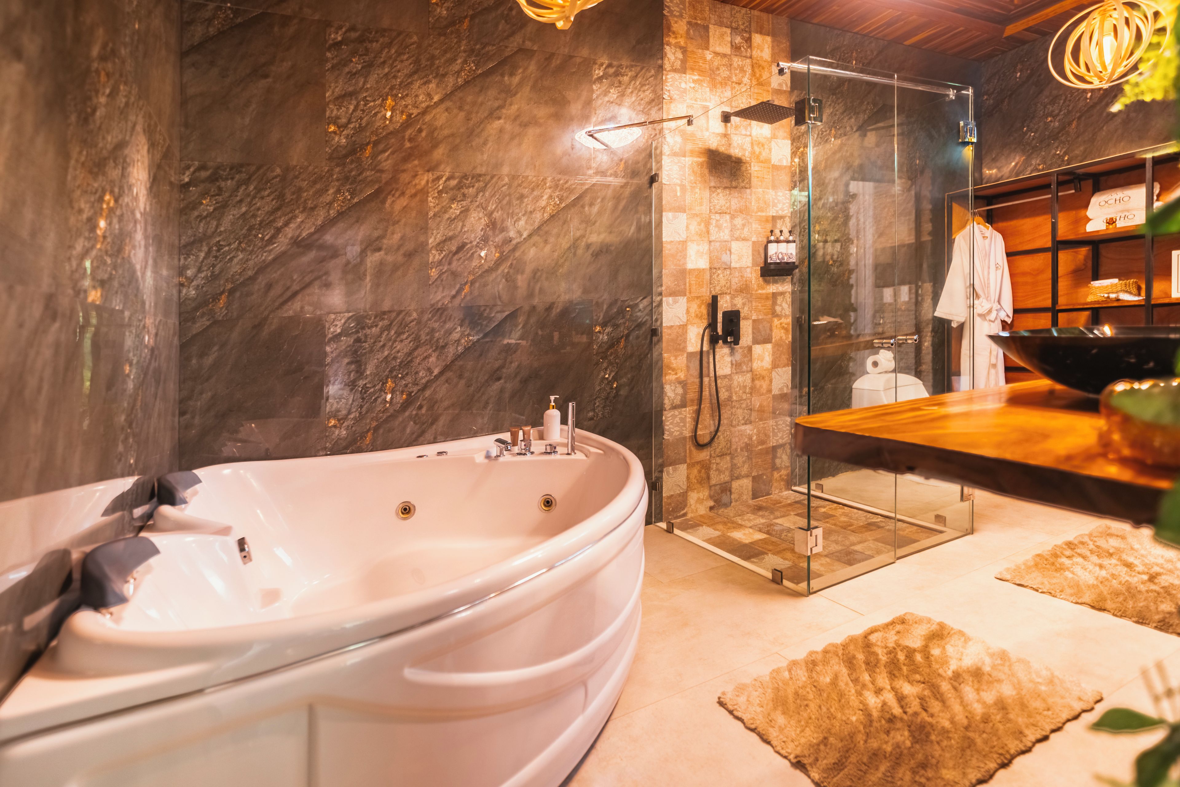 A modern bathroom with a freestanding bathtub, a glass-enclosed shower, and a wooden vanity with a towel rack.