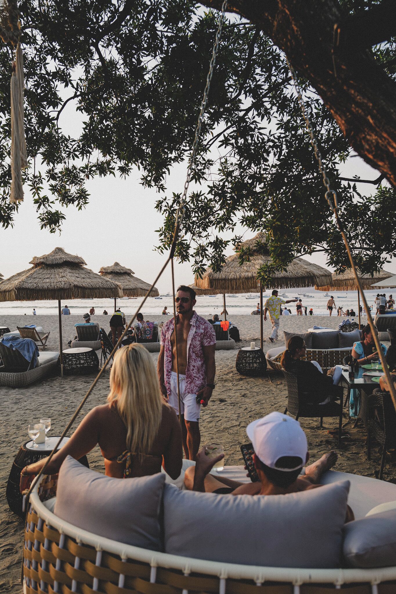 A beachside setting with thatched umbrellas, wicker lounge chairs, and a relaxed atmosphere.