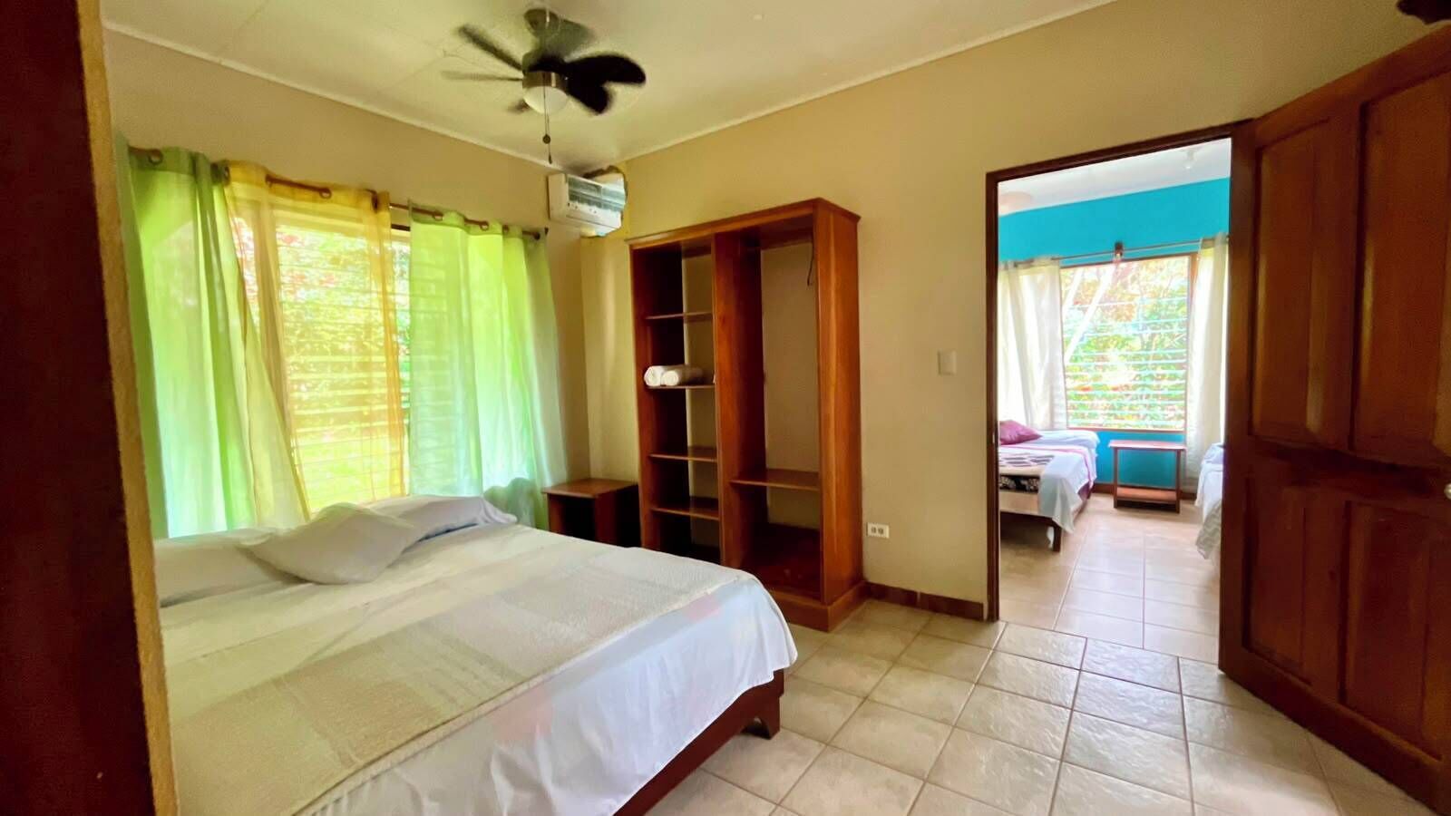 A bedroom with a bed, a wardrobe, and a ceiling fan.