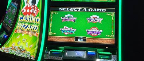 A casino gaming machine with a green-lit display and a selection screen.