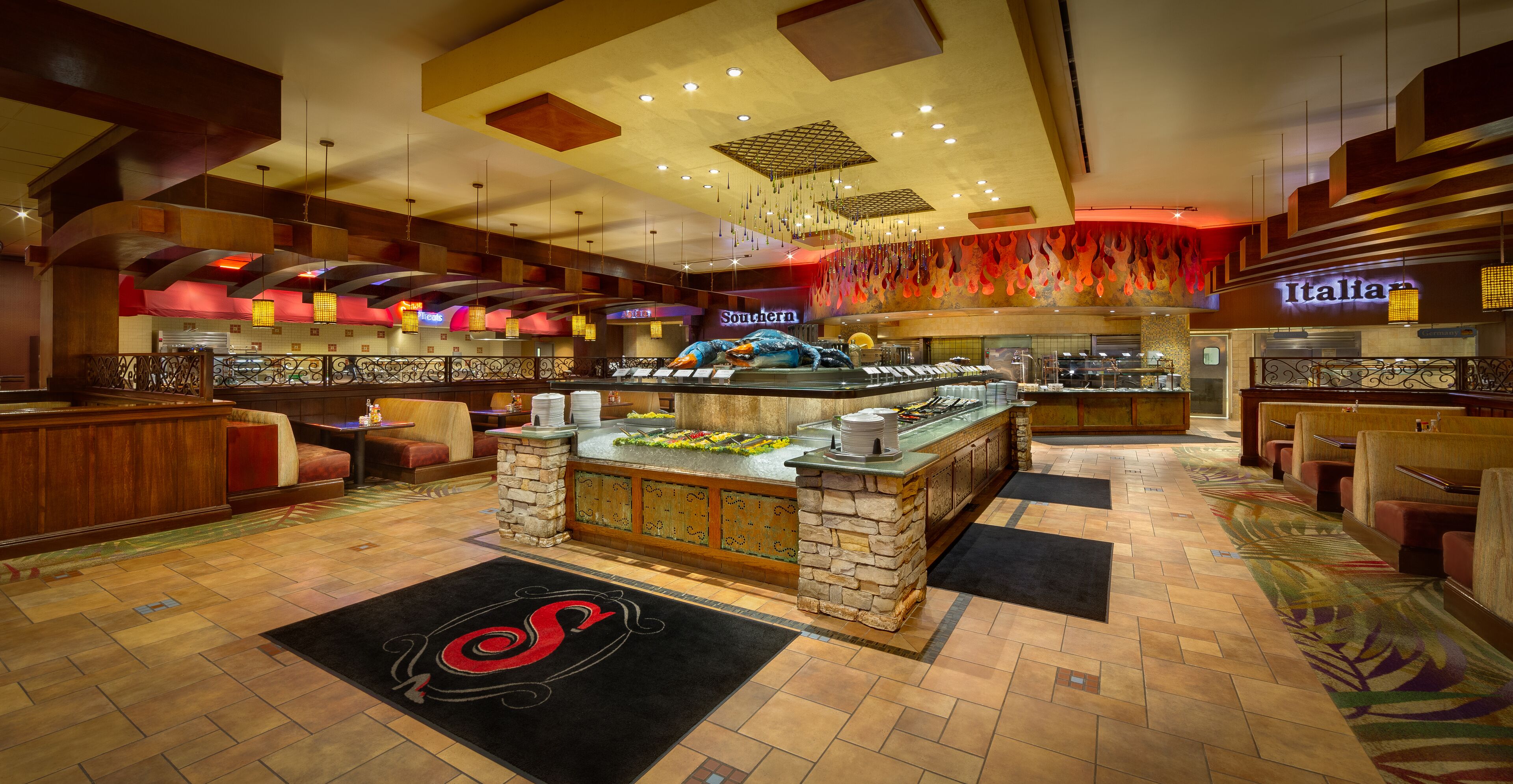 Un ristorante con buffet, un'area bar e una zona salotto con sedie.