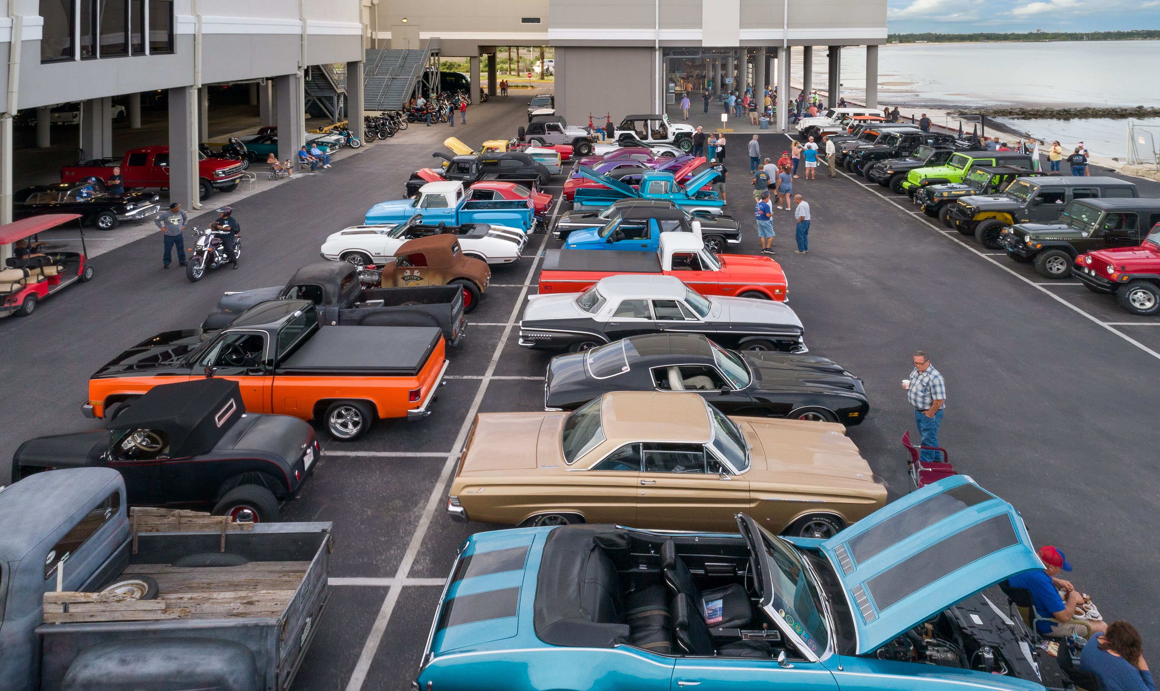 Un parking rempli de voitures anciennes de différents modèles.
