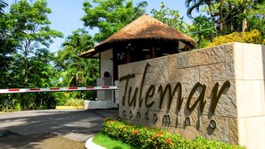 A gated entrance with a stone sign reading "Tulemar Condominium."