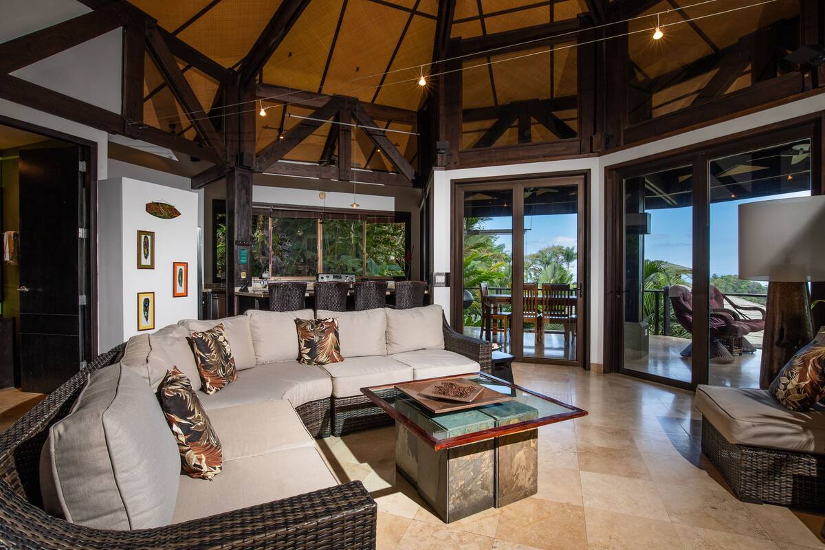 Amplia sala de estar con un sofá grande, una mesa de centro y vistas al exterior.