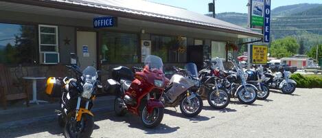 A motel with a row of motorcycles parked in front.