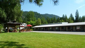 Una cabaña con una zona de picnic cubierta y un edificio alargado con varias habitaciones.