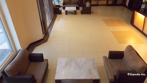 A hotel lobby with a seating area, a marble coffee table, and a reception desk. - MO2 Westown Hotel Bacolod - Mandalagan (Bacolod)