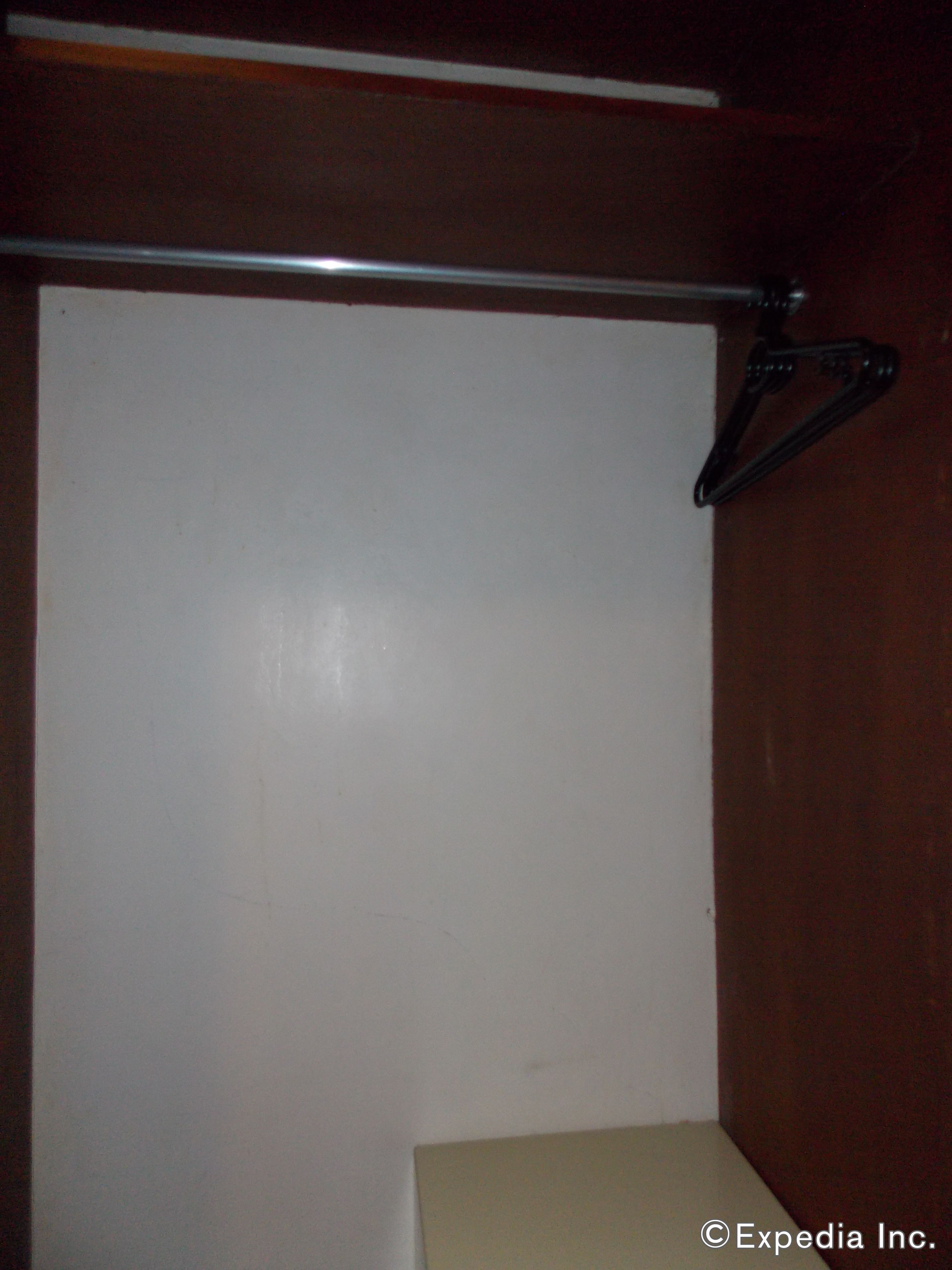 Una habitación con una pared blanca, una puerta de madera y una barra de metal.