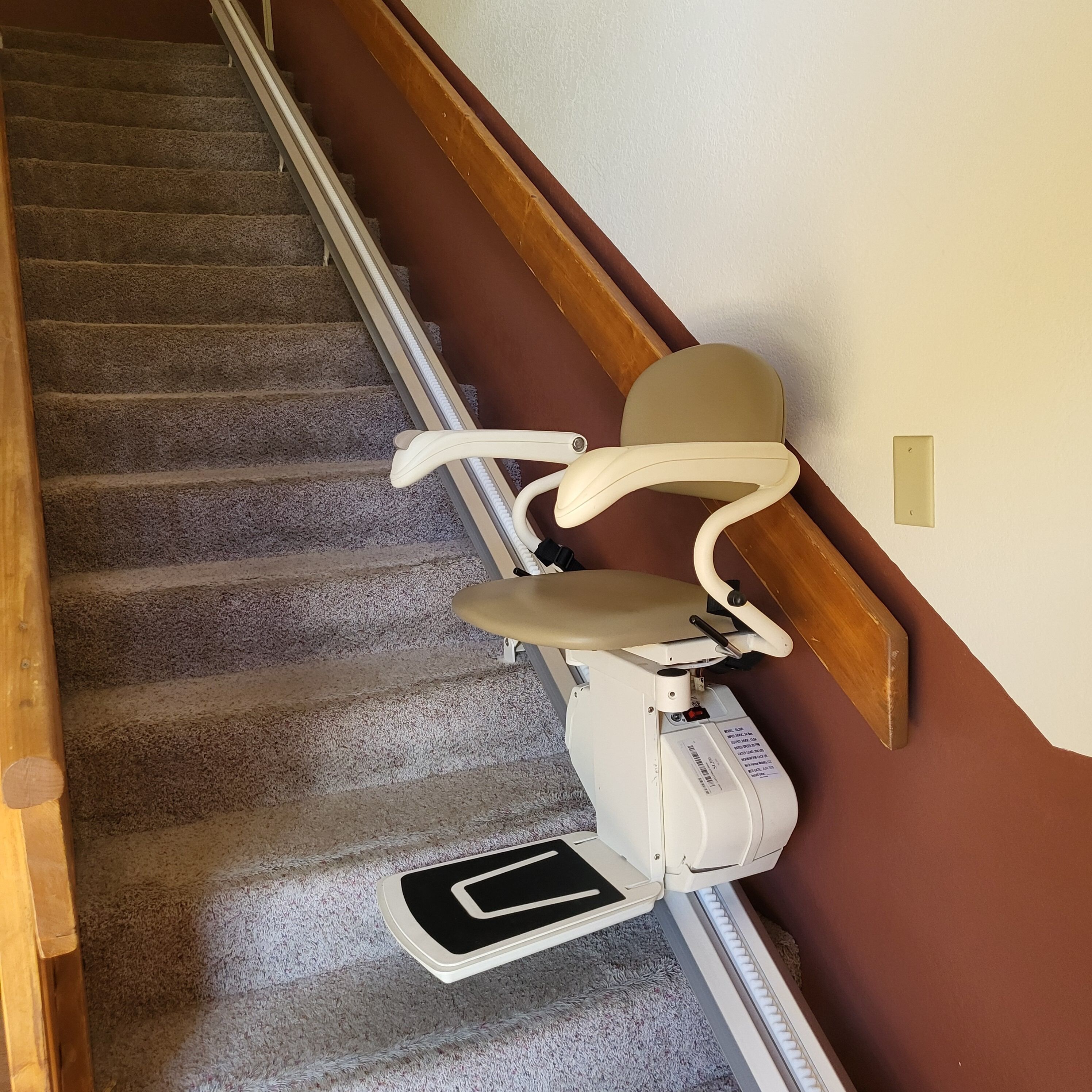 Eine Teppichstufe mit Handlauf, ein weißer Stuhl und ein weißes Objekt auf der Treppe.