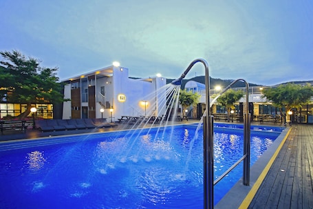 Una piscina al aire libre de temporada, sombrillas