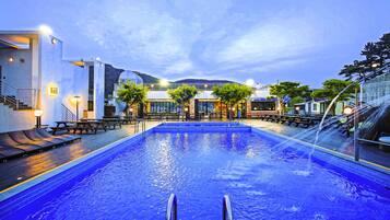 Relax by the pool surrounded by comfortable lounge chairs and tables.
