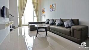 Una sala de estar moderna con un sofá, una mesa de centro y un televisor sobre un mueble.