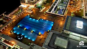 Vista aérea de un hotel con una piscina grande, varias edificaciones y zonas exteriores bien iluminadas.