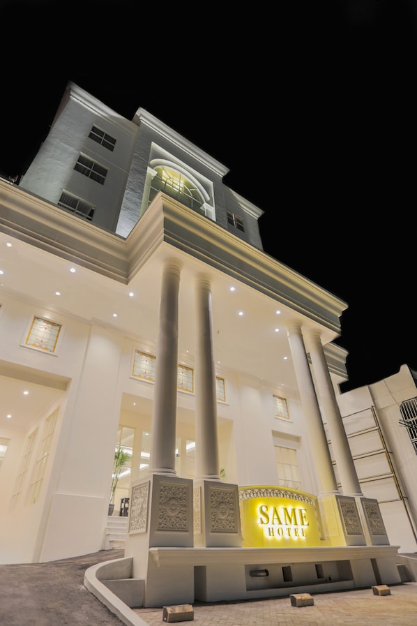 Entrada de hotel con un letrero iluminado que dice "SAME HOTEL".