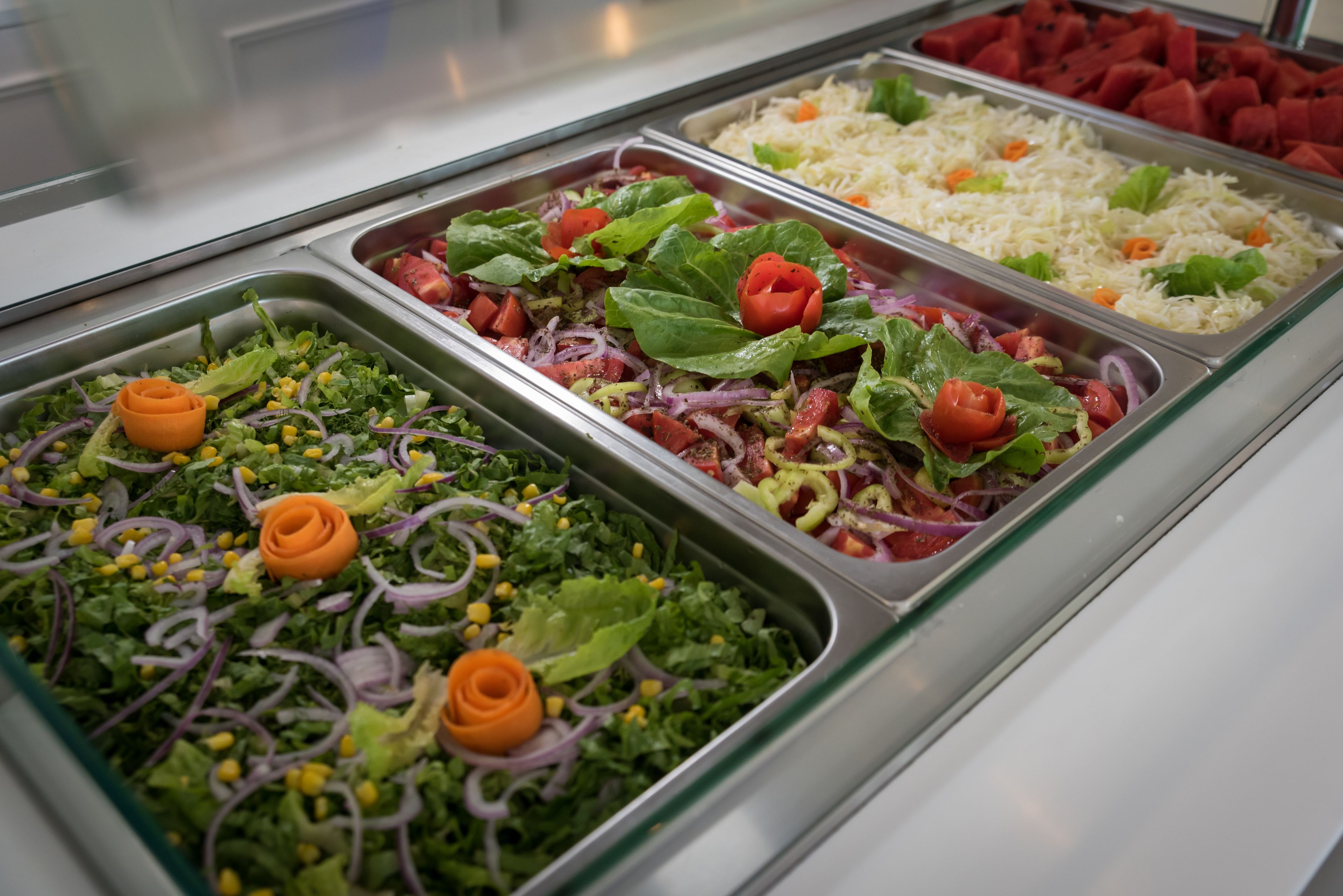 A buffet with various salads and rice dishes.