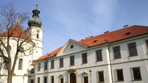 A historic building with a central courtyard, a bell tower, and a symmetrical facade with evenly spaced windows. - Hotel Adalbert (Prague)
