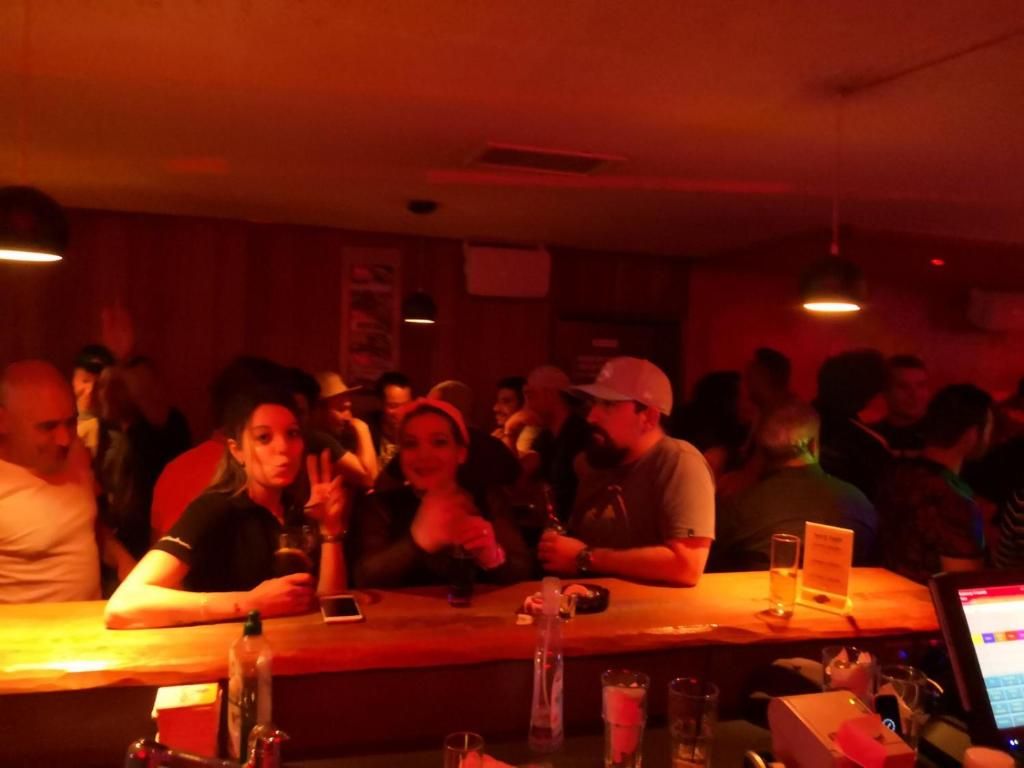 A crowded bar with tables and people seated.