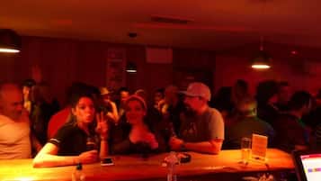 A crowded bar with tables and people seated.