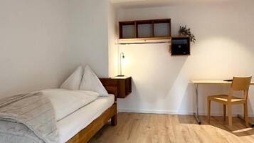 Une chambre à coucher avec un lit en bois, un bureau et une chaise.