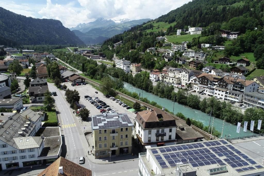 Eine Stadt mit einem Fluss, Gebäuden und einer Straße.
