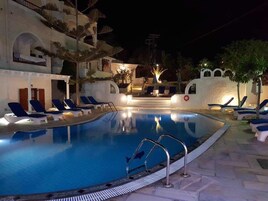 Una piscina al aire libre de temporada, tumbonas