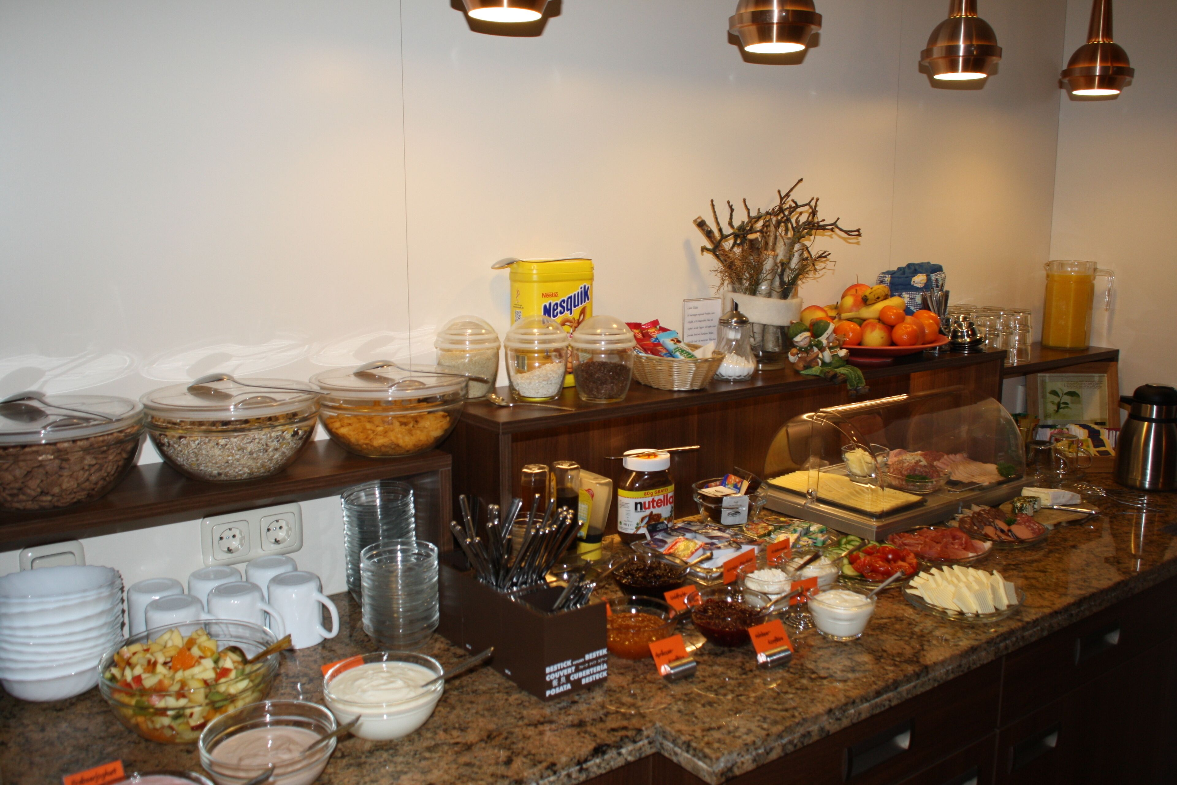Una mesa de buffet con diferentes alimentos, salsas y utensilios.